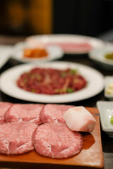 Korean Style Barbecue Grill BBQ. Hanwoo rare beef tongue meat on plate with soft focus