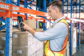 Smart smiling caucasian warehouse man,worker,manager use digital tablet to check goods on shelf for...