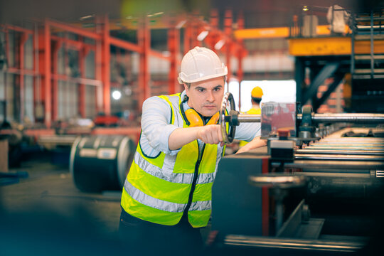 Smart professional Caucasian quality control,Industrial,factory engineer,technician,worker man in safety helmet operate machine in steel metal sheet production,manufacture worker concept in copy space