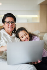 Fototapeta premium Joyful moments of connection between grandmother and granddaughter at home