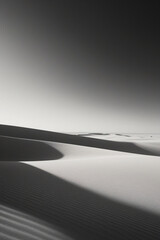 Dramatic black and white desert landscape with flowing sand dunes and soft light