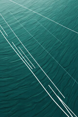 Abstract pattern of white lines on a textured teal green water surface