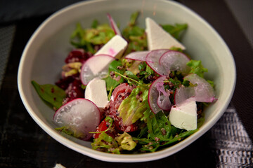 Fresh and Colorful Salad Bowl Featuring Vibrant Greens, Radishes, Cherry Tomatoes, and Creamy Feta Cheese for a Healthy Culinary Experience