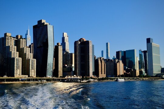 Manhattan Skyline with Ferry and Shimmering River (New York, New York, USA)
