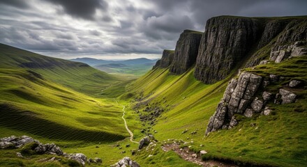 Majestic Scottish Highlands Valley Under Dramatic Clouds and Sunlight Revealing a Winding Path Through Green Rolling Hills and Rugged Rocky Cliffs