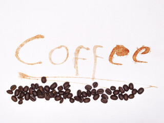 Coffee stain artfully spells 'Coffee' on white paper, accompanied by a line of roasted coffee beans