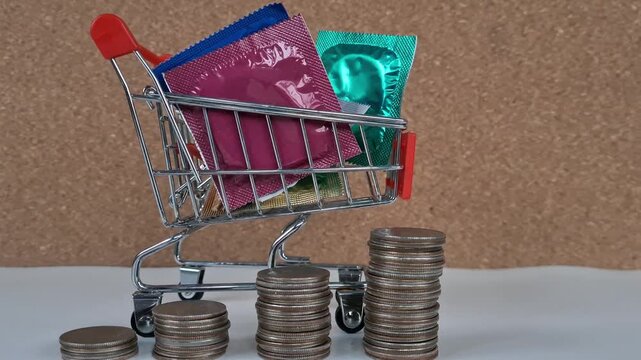 Shopping cart filled with colorful packages and stacked coins shows a humorous take on budgeting for safe health