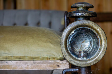 old oil lamp mounted on a vintage horse-drawn carriage. Detail of a historical mode of transport.