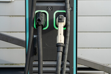 Electric Vehicle Charging Station With Dual Connectors: Close-Up Of Modern EV Power Supply Cables...