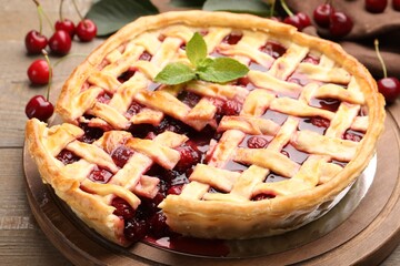 Tasty cut cherry pie and berries on wooden table, closeup