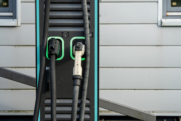 Electric Vehicle Charging Station With Dual Connectors: Close-Up Of Modern EV Power Supply Cables...