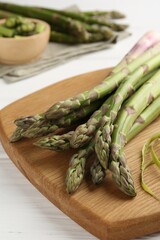 Fresh raw asparagus spears on white wooden table, closeup