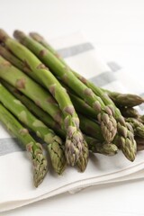 Fresh raw asparagus spears on white wooden table, closeup