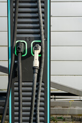 Electric Vehicle Charging Station With Dual Connectors: Close-Up Of Modern EV Power Supply Cables...