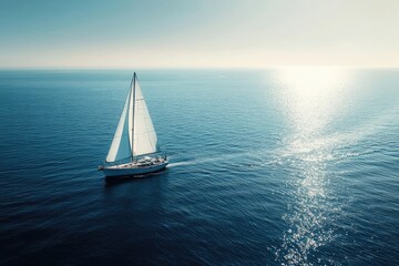 A sailboat glides across a vast, tranquil ocean.  Sunlight reflects on the water's surface