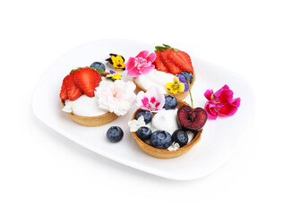 Sweet tartlets with berries and flowers isolated on white. Delicious dessert