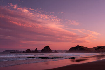 experience breathtaking sunset along pristine coastline of new zealand where sun gracefully dips below horizon