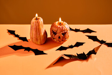 Halloween-style candles on a orange background. Festive decor.