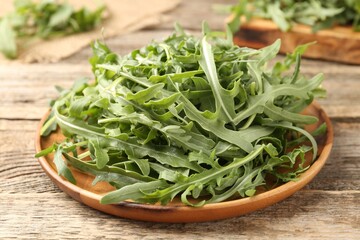 Fresh ripe green arugula leaves on wooden table, closeup