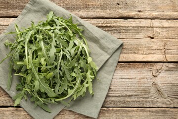Fresh ripe green arugula leaves on wooden table, top view. Space for text