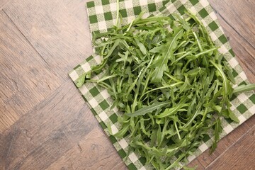 Fresh ripe green arugula leaves on wooden table, top view. Space for text