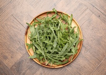 Fresh ripe green arugula leaves on wooden table, top view