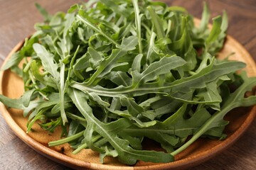 Fresh ripe green arugula leaves on wooden table, closeup