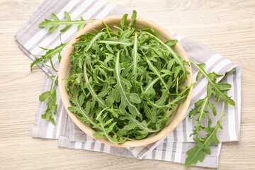Fresh ripe green arugula leaves on light wooden table, flat lay
