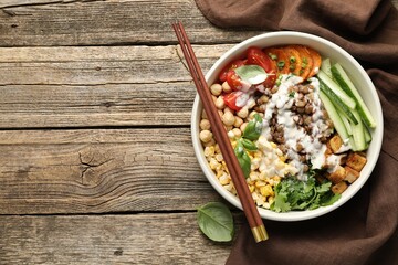 Healthy vegetarian food. Delicious Buddha bowl served on wooden table, top view. Space for text