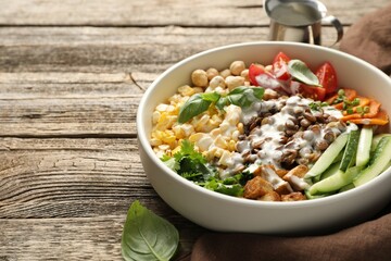 Healthy vegetarian food. Delicious Buddha bowl served on wooden table, closeup. Space for text
