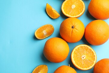 Fresh ripe oranges on light blue background, flat lay. Space for text