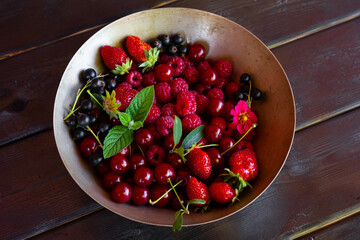  Different types of berries raspberry, strawberry, cherry and currant in a bowl