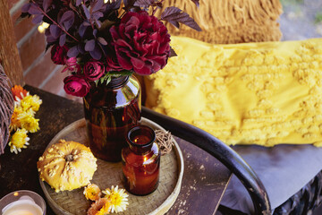 Autumn cozy mood composition on the porch. Pumpkins, autumn flowers, candles on the tray