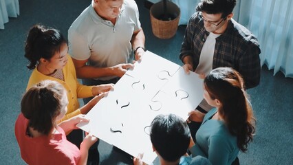 Top view of smart business people put last piece of jigsaw puzzle together to complete puzzle and...