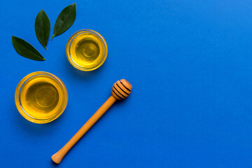 Honey jar with wooden honey dipper on white background top view with copy space. Delicious honey bottle