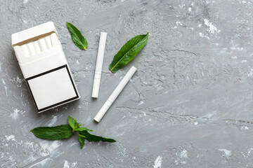 Pack of menthol cigarettes and fresh mint on colored table, Menthol cigarettes top view flat lay