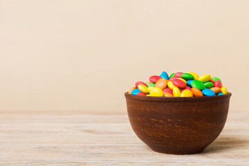 Multicolored candies in a bowl on a colored background. birthday and holiday concept. Top view with...