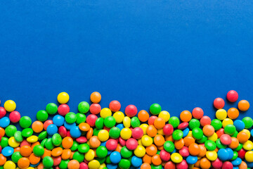Mixed collection of colorful candy, on colored background. Flat lay, top view. frame of colorful chocolate coated candy