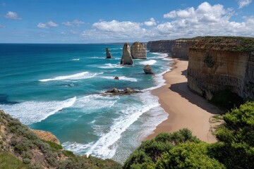 Spectacular coastal scenery featuring towering rock formations along a sandy beach under a bright sunny sky