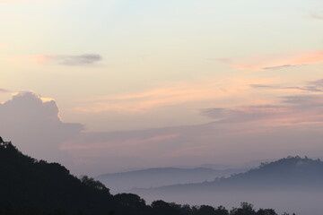 A tranquil mountain range landscape with a mesmerizing dusk sky. The silhouette of the mountains creates a sense of serenity