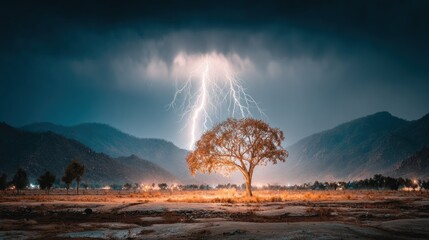 Dramatic lightning strike over a lone tree in a mountainous landscape