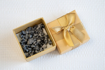 Tumbled close up snowflake obsidian on grey textured background