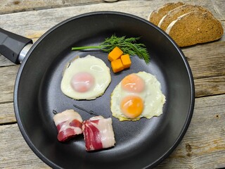 Top view of a skillet breakfast of fried eggs and delicious bacon
