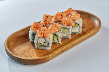 Delicious sushi rolls topped with fresh salmon and served on a wooden plate, showcasing vibrant colors and textures that tantalize the palate.