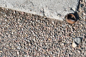 Gravel with old iron pipe cut clean with concreate and gravel.