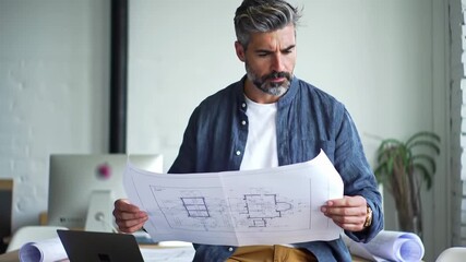 Man reviewing architectural blueprints in an office