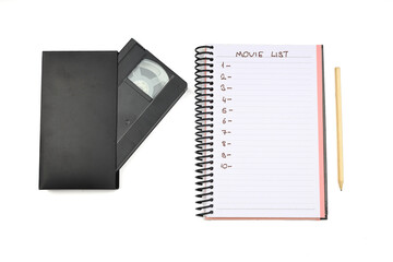 Black VHS video tape cassette with blank label isolated on white background. And empty movie list.