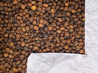 White crumbled paper frame texture on coffee beans background
