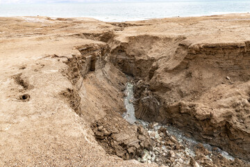 A hot  mineral spring flows along winding channel towards Dead Sea in southern Israel