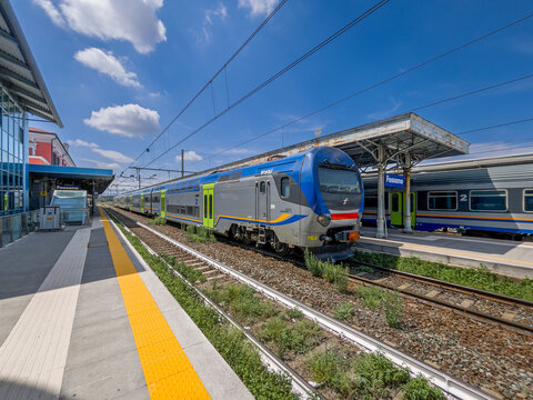 Fossano, Italy - July 23, 2025: view of the tracks and platforms at Fossano Station with the High Frequency Train (TAF), a double-decker light rail train, here with new regional train livery.